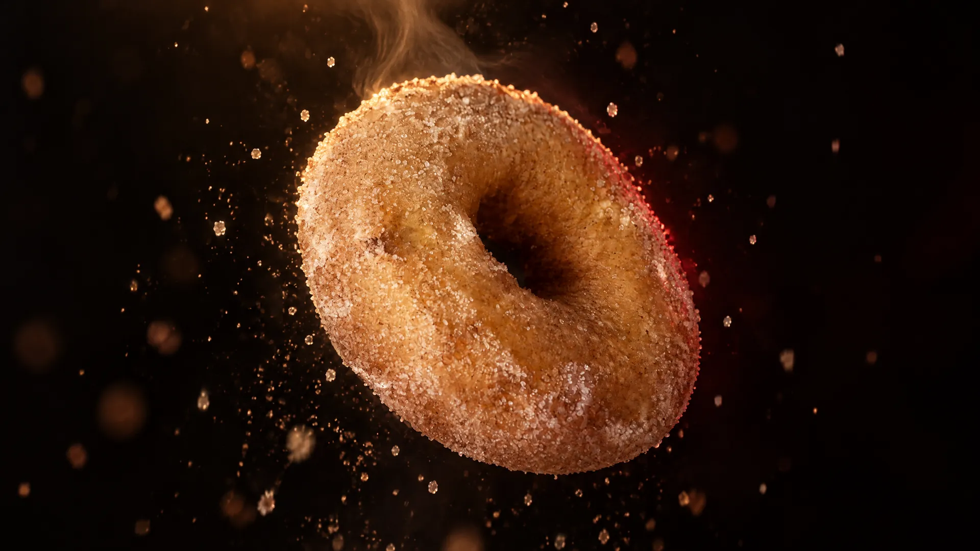 A hot cinnamon sugar doughnut from Devilish Doughnuts, sugar falling around it