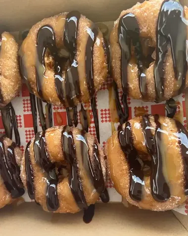 A box of chocolate drizzled doughnuts